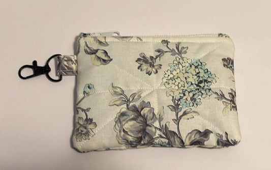 Floral-patterned pouch with a key ring on a light background